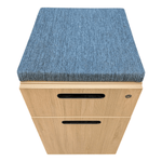 a wooden file cabinet with a blue cushion
